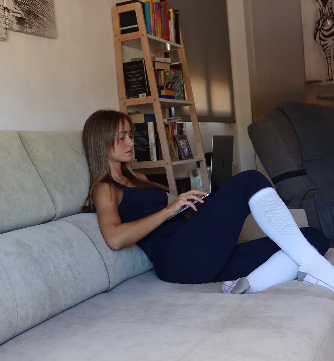 Mujer descansando en el sofá con calcetines de compresión Kompresion